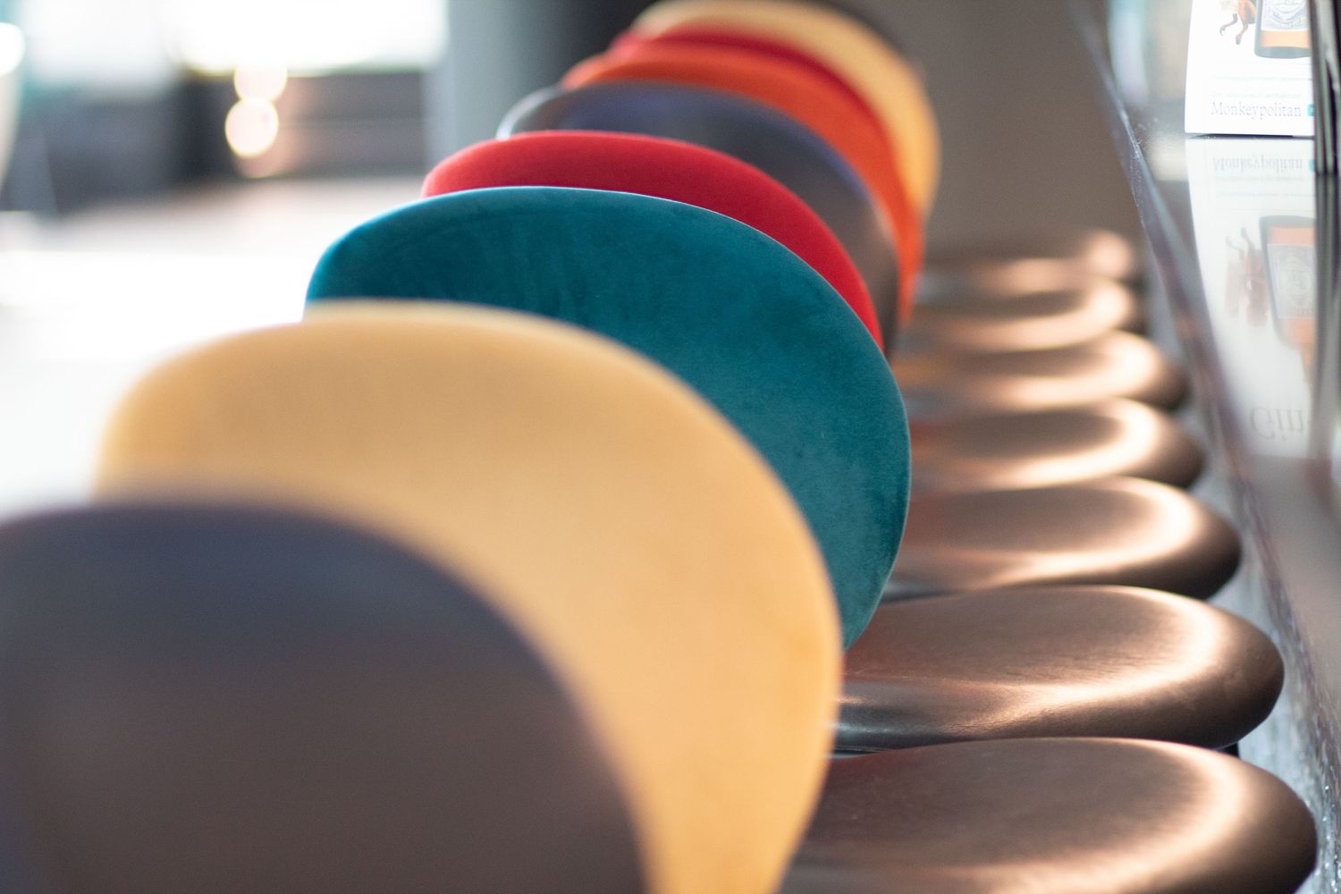 Close-up of a row of colourful bar stools