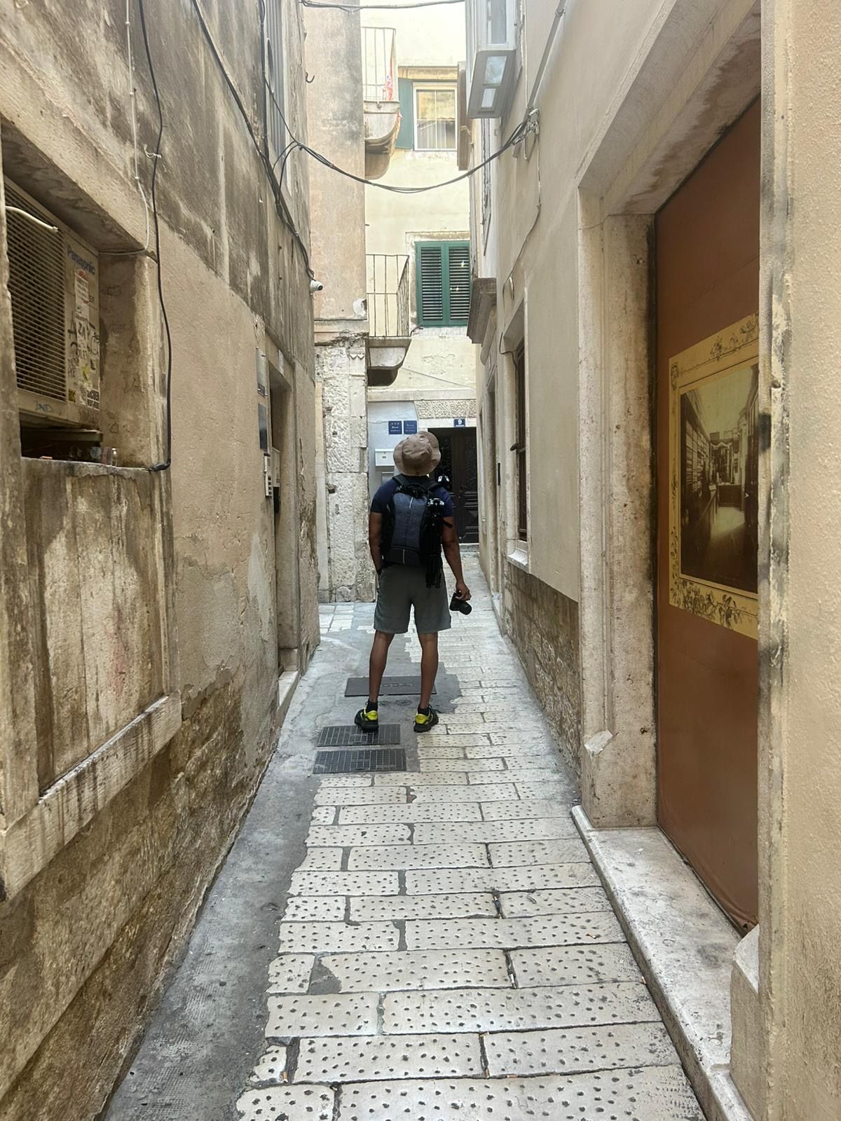 Ritchie walking down a narrow stone lane with his camera
